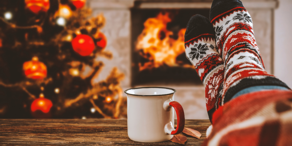 Women feet in front of wood burning fireplace at Christmas -